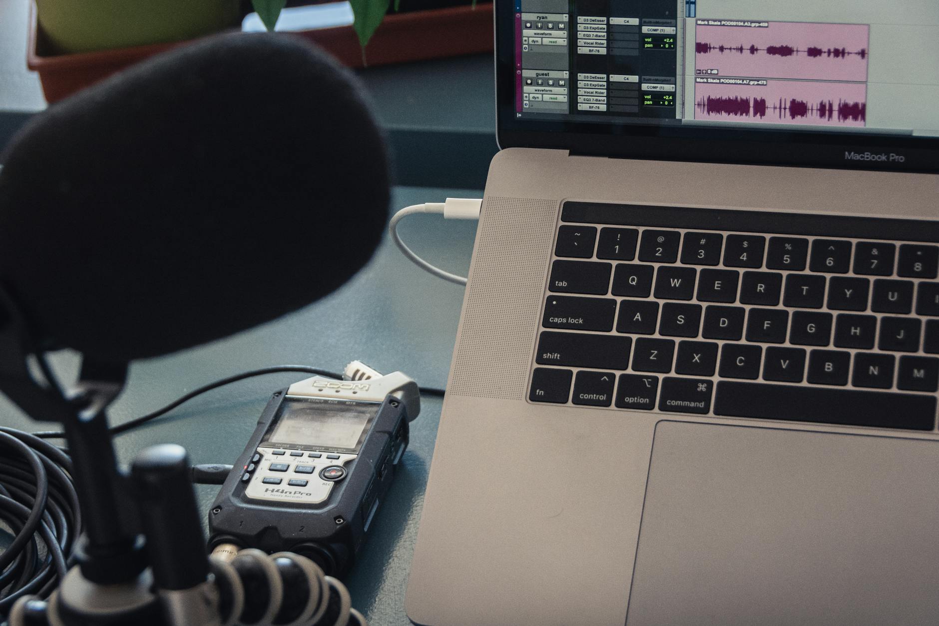 Microphone and laptop setup for audio recording in a studio environment.